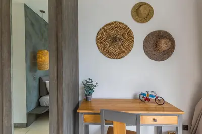 a dining room with a table and straw hats on the wall at Villa Irma in Seminyak