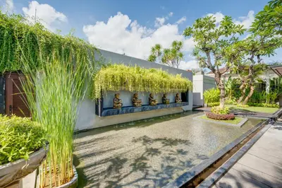 a garden with tall grass on the side of a building at Villa Jerami & Spa in Seminyak