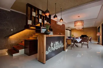 a lobby with a staircase and a dining room at Natya Villa Jimbaran in Jimbaran