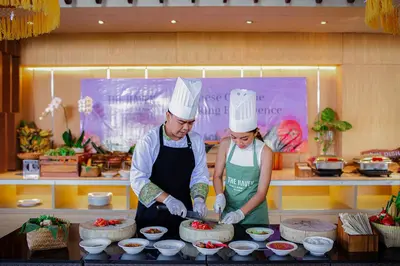 two people in chefs hats preparing food in a kitchen at THE HAVEN Bali Seminyak in Seminyak