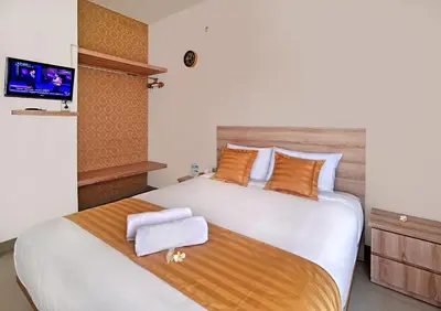 a bedroom with a large bed with a flat screen tv at Wika Bali Beach House in Jimbaran