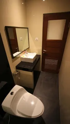 a bathroom with a white sink and a mirror at The Surya Kuta Villa in Kuta