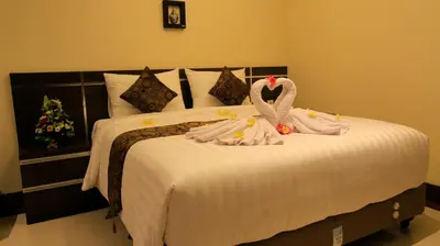 a bed with two swans on top of it at The Surya Kuta Villa in Kuta