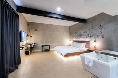 a bedroom with a bed and a tub and a sink at Stark Boutique Hotel and Spa in Kuta