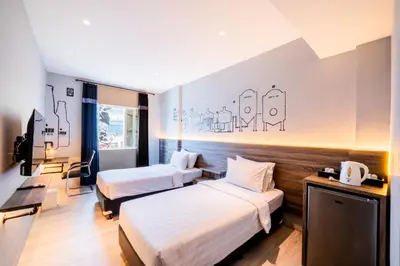 a hotel room with two beds and a television at Stark Boutique Hotel and Spa in Kuta
