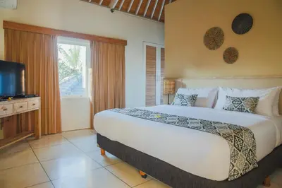 a bedroom with a large bed and a television at Villa La Luvier in Canggu