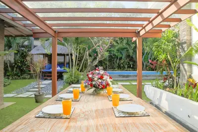 a wooden table with plates and glasses of orange juice at Villa La Luvier in Canggu
