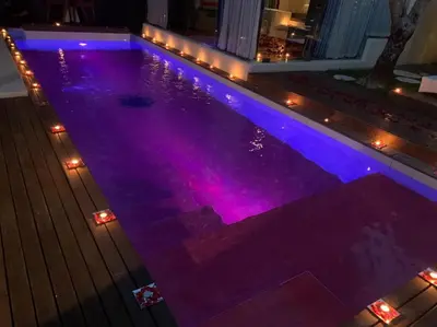 a swimming pool with purple lights in a house at Kiss Bali Villas in Seminyak