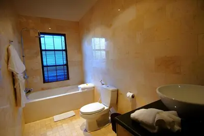 a bathroom with a tub and a toilet and a sink at Danoya Private Luxury Residences in Seminyak