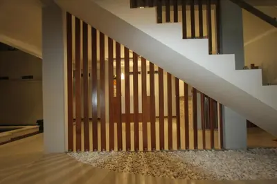 a staircase with a wooden door in a house at Tom Guest House in Legian