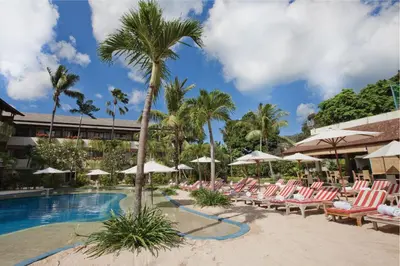 a pool at the resort with lounge chairs and palm trees at Blu-Zea Resort by Double-Six in Seminyak