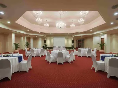 a banquet hall with white tables and white chairs at Blu-Zea Resort by Double-Six in Seminyak