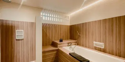 a bathroom with wooden walls and a tub and a sink at Aruni Bali Jimbaran Boutique Villa in Jimbaran