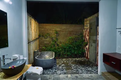 a bathroom with a bath tub and a sink at The Garden Villa in Sanur