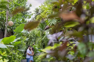a man and a woman standing in front of a garden at Le Jardin Villas Seminyak in Seminyak