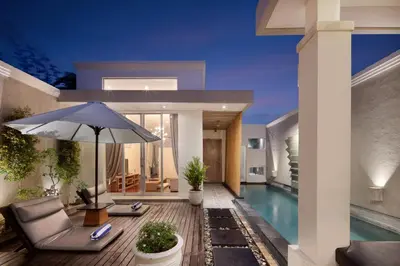 a house with a swimming pool and an umbrella at The Seiryu Boutique Bali Villas in Seminyak