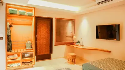 a bedroom with a bed and a television on the wall at Annora Villas Seminyak in Seminyak