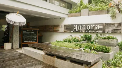a restaurant with a bench with plants in it at Annora Villas Seminyak in Seminyak