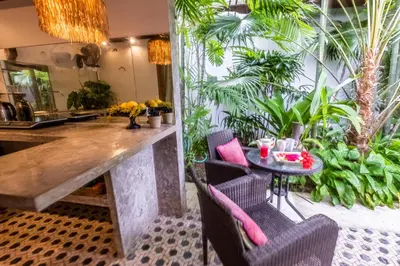 a kitchen with a table and chairs and plants at Baby Melon Villas in Seminyak