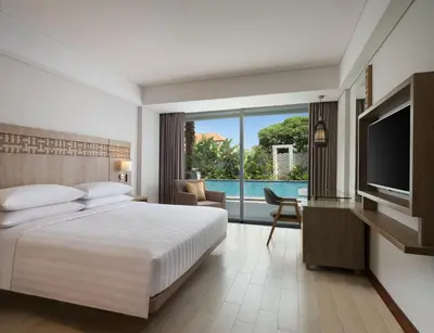 a hotel room with a bed and a television at Fairfield by Marriott Bali Legian in Legian