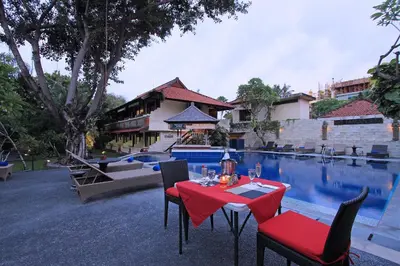 a table and chairs next to a swimming pool at The Taman Ayu Seminyak 10 Minute walking to the BEACH in Seminyak