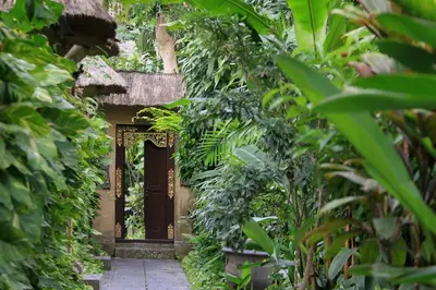 a door in the middle of a garden with plants at The Taman Ayu Seminyak 10 Minute walking to the BEACH in Seminyak