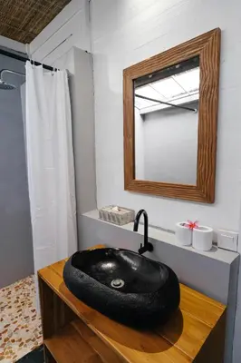 a bathroom with a black bowl sink on a wooden counter at Easy Surf Camp in Kuta