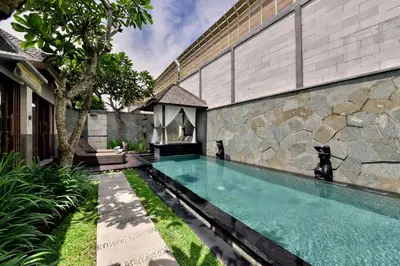 a swimming pool in front of a building at The Khayangan Dreams Villa, Seminyak in Seminyak