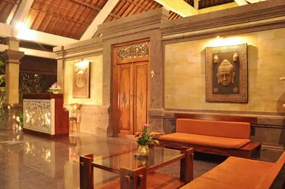 a lobby with a table and a chair and a statue at Bali Aroma Exclusive Villas in Seminyak