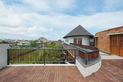 a balcony with a wooden railing and a house at djabu Seminyak Hotel in Seminyak