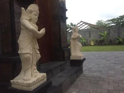 two statues of cherubs on the side of a building at Dikubu Belong Seminyak in Seminyak