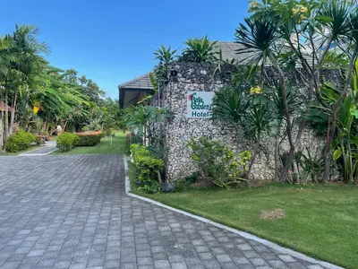 a stone wall with a sign that reads garden hotel at Raja Gardens Hotel in Seminyak