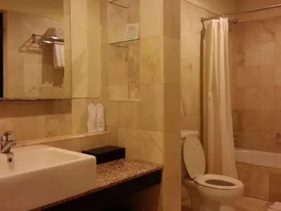 a bathroom with a sink and a toilet and a shower at Legian Paradiso Hotel in Legian