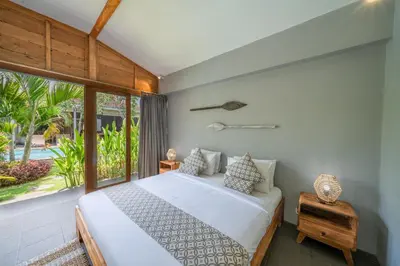a bedroom with a bed and a large window at Villa Nahema - 4BR Villa in Seminyak Next to the Beach in Canggu