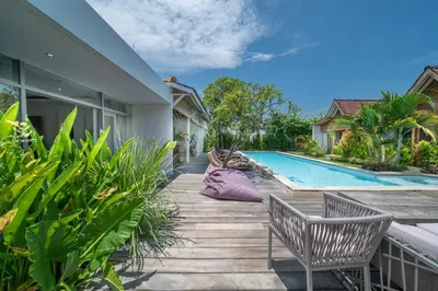 a house with a purple pillow sitting on a deck next to a swimming pool at Villa Nahema - 4BR Villa in Seminyak Next to the Beach in Canggu