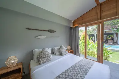 a bedroom with a white bed and a large window at Villa Nahema - 4BR Villa in Seminyak Next to the Beach in Canggu
