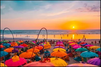 a crowd of people sitting on a beach with umbrellas at The Club Villas Seminyak in Seminyak
