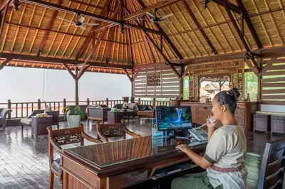a woman sitting at a desk with a computer at The Club Villas Seminyak in Seminyak
