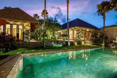 a house with a swimming pool in front of a house at Rachline Villa in Kerobokan
