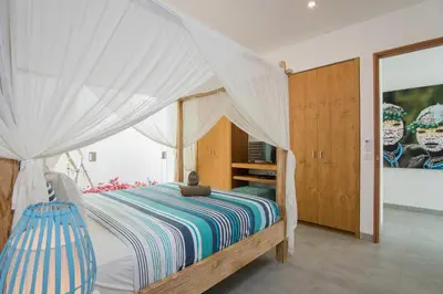 a bedroom with a bed with a canopy at Villa Kobe Beachside Berawa Canggu location in Canggu