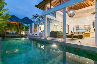 a villa with a swimming pool and a house at Villa Kobe Beachside Berawa Canggu location in Canggu