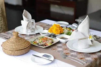 a table with plates of food on a table at Alaya Dedaun Kuta in Legian