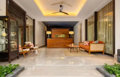 a living room with a couch and a ceiling fan at Alaya Dedaun Kuta in Legian