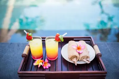 a tray with a plate of food and two glasses of juice at Jay's Villa Umalas in Canggu