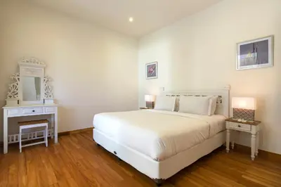 a white bedroom with a bed and a mirror at Dream villa Seminyak in Seminyak