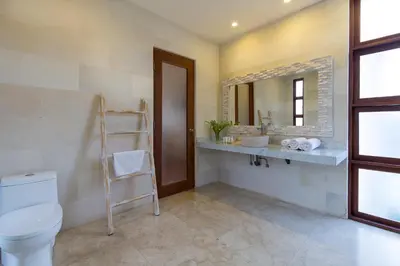 a bathroom with a toilet and a mirror at Dream villa Seminyak in Seminyak