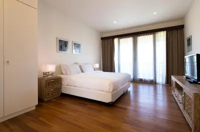 a white bedroom with a bed and a television at Dream villa Seminyak in Seminyak