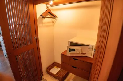 a small kitchen with a microwave and a door at Kuta Paradiso Hotel in Kuta