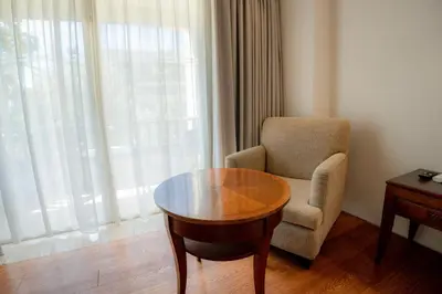 a room with a table and a chair and a window at Kuta Paradiso Hotel in Kuta