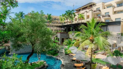 an image of a hotel with a pool and palm trees at Kuta Paradiso Hotel in Kuta